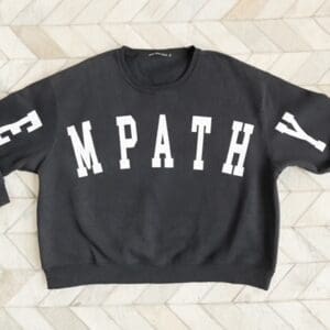 A black sweatshirt with the word empathy on it.